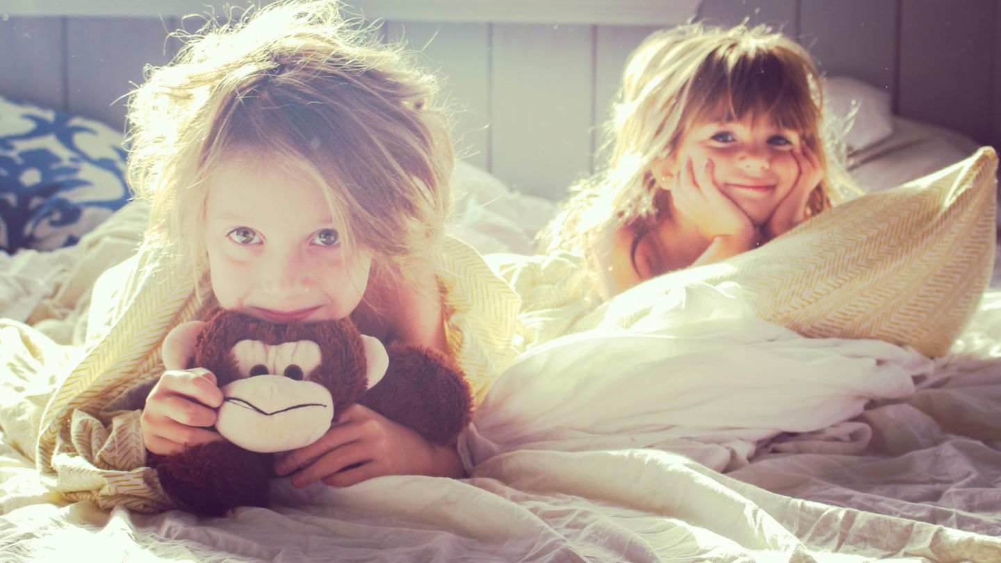 Zwei kleine Mädchen liegen im Bett