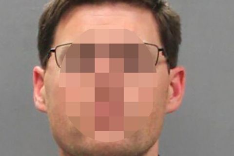 Ein Mann mit dunkelblondem Seitenscheitel, Brille und blau-grauem Karohemd schaut gerade in die Kamera
