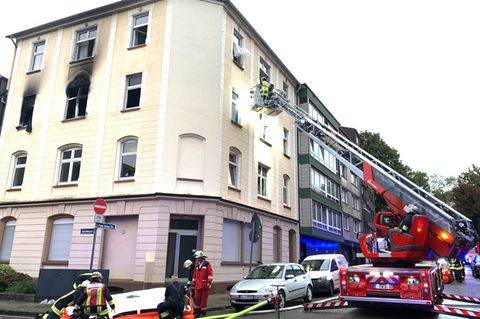 Einsatzkräfte der Feuerwehr sind vor einem Haus im Einsatz