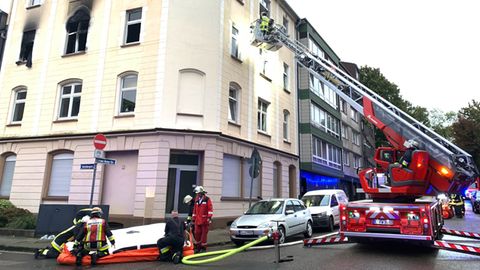 Einsatzkräfte der Feuerwehr sind vor einem Haus im Einsatz