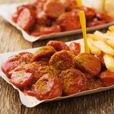 Currywurst  Zutaten:   1 Zwiebel (100 g), 1 Knoblauchzehe, 1 EL Rapsöl, 30 g brauner Zucker, 1 ½ EL Currypulver, 600 ml Bio-Tomatensaft (Reformhaus), Salz 2 TL fein geriebene Ingwerwurzel, Paprikapulver, rosenscharf (zum Nachwürzen), 1–2 TL Weinessig  Zubereitung:   Zwiebel und Knoblauch abziehen, fein würfeln und in einem Topf in Öl bei milder Wärmezufuhr unter Rühren andünsten. Zucker darüber streuen und karamellisieren lassen. Aufpassen, die Zwiebeln dürfen nur leicht bräunen.  Currypulver unter die Mischung rühren und mit 200 ml Tomatensaft ablöschen. Mischung 10 Minuten köcheln und mit dem Stabmixer fein pürieren.  Den restlichen Tomatensaft und ½ TL Salz unterrühren und die Sauce auf 450–500 ml langsam offen dickflüssig einkochen. Ab und zu umrühren. 4. Ingwer unterrühren nochmals aufkochen und abkühlen lassen. Mit eventuell ½ TL Paprikapulver, Salz und Essig abschmecken. Darauf achten, dass eine aufgewärmte Sauce intensiv-würziger schmeckt als eine kalte Sauce.  Dazu gibt es Bratwurst und frisch gebackene Pommes frites. Für den Vorrat die heiße Currysauce in kleine saubere und vorgewärmte Twist-off-Gläser füllen, sofort verschließen und auf den Deckel gestellt erkalten lassen