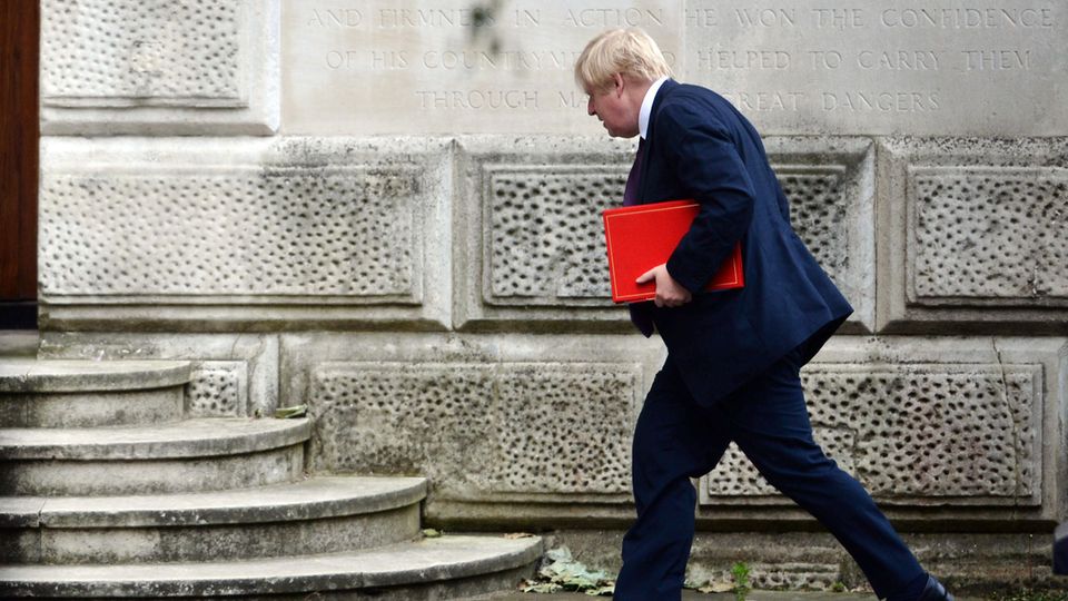 Boris Johnson mit einer roten Mappe unterm Arm