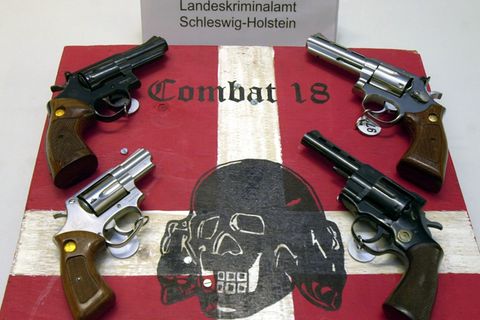Sichergestellte Waffen und ein Schild der kriminellen Neonazi-Gruppe "Combat 18" (Archiv)