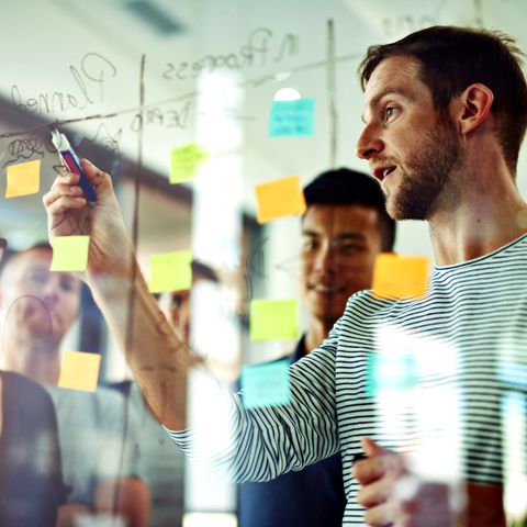 Meeting vor einem transparenten Glasboard