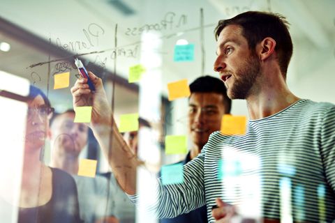 Meeting vor einem transparenten Glasboard