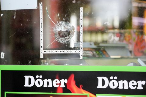 Markierungen der Polizei kleben um einen Einschuss in der Schaufensterscheibe eines Dönerladens in Halle