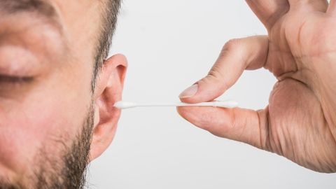 Spinne im Ohr: Ein Mann benutzt ein Wattestäbchen