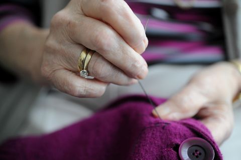 Eine Seniorin näht an einer Jacke