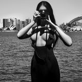 Andrea Westcott posiert vor der Skyline von Sydney und der charismatischen Silhouette des Opernhauses.