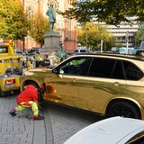Ein goldener SUV wird nahe der Königsallee in Düsseldorf abgeschleppt