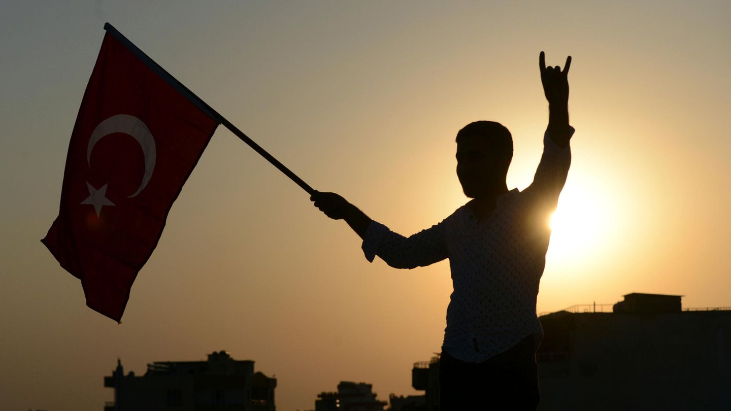 Ein Mann im türkischen Akcakale schwenkt eine Nationalflagge