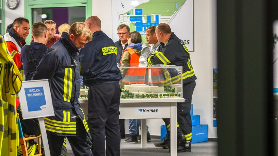 Sachsen-Anhalt, Haldensleben: Mitarbeiter der Feuerwehr stehen im Hermes Logistikzentrum
