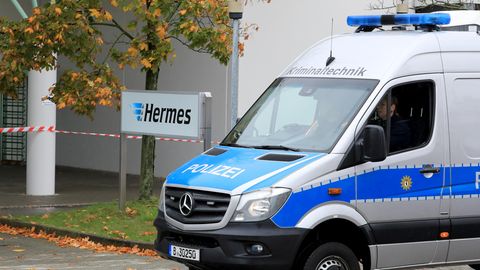 Ein Polizeiauto von der Kriminaltechnik fährt auf das Gelände des Paketdienstleisters Hermes