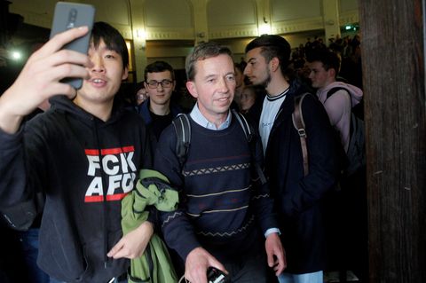 Ein Student im schwarzen "FCK AFD"-Kapuzenpullover macht mit seinem Smartphone ein Selfie mit Bernd Lucke