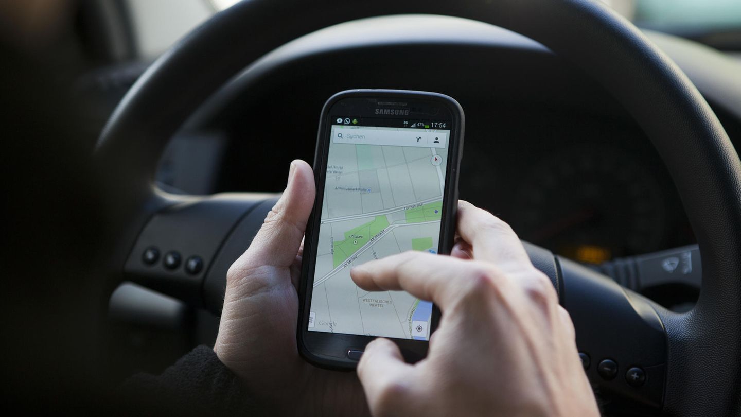Ein Mann nutzt Google Maps am Steuer (Symbolfoto). Ein Ort in Italien warnt