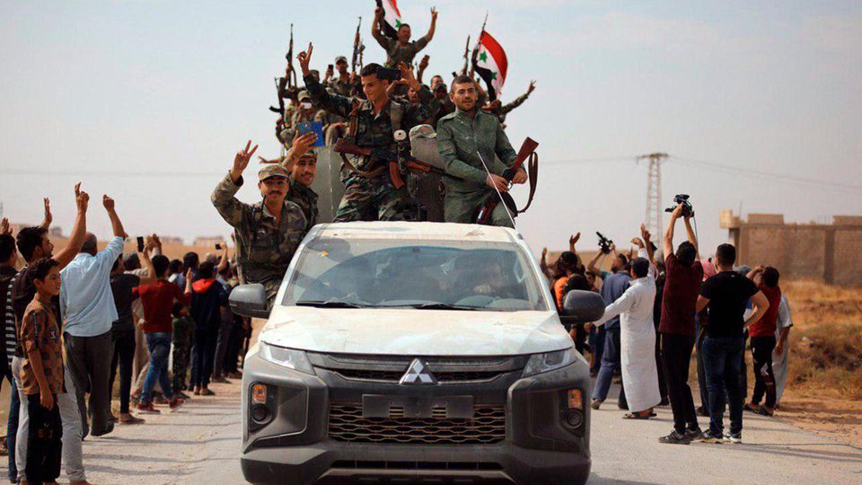 VOE STERN 43/2019 In this photo released by the Syrian official news agency SANA, people welcome Syrian troops as they enter the town of Ein Issa, north of Raqqa, Syria, Monday, Oct 14, 2019. Syrian troops moved east from Aleppo province to Raqqa where ... Syrische Soldaten auf einem Transporter. Zivilisten winken ihnen zu.