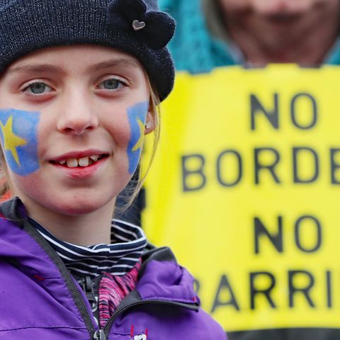 Ein Mädchen mit aufs Gesicht gemalten EU-Sternen lächelt
