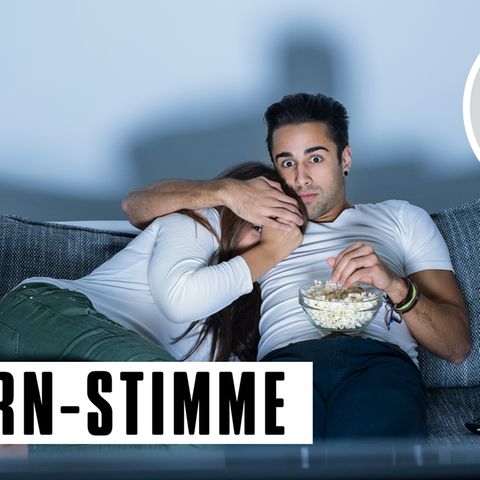 Paar auf einem Sofa, Mann hält der Frau die Augen zu