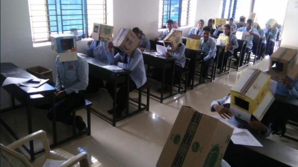 Prüfung in Indien Schüler tragen bei einer Prüfung Kartons auf den Köpfen