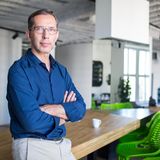 Mann steht in seinem Büro