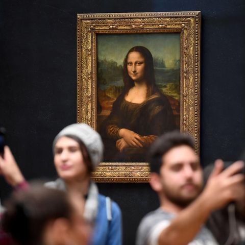 Besucher lassen sich vor der Mona Lisa im Louvre fotografieren