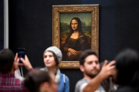 Besucher lassen sich vor der Mona Lisa im Louvre fotografieren