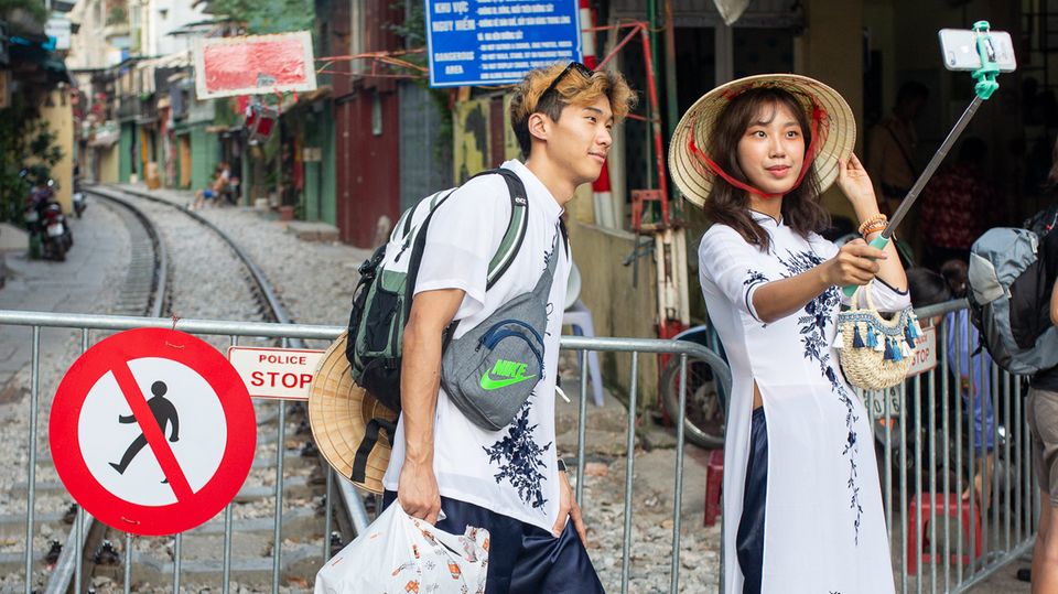 Instagram-Hype: Vietnam, Hanoi: Ein Paar macht ein Selfie an der Absperrung zur "Train Street" Vietnam, Hanoi: Ein Paar macht ein Selfie an der Absperrung zur "Train Street"