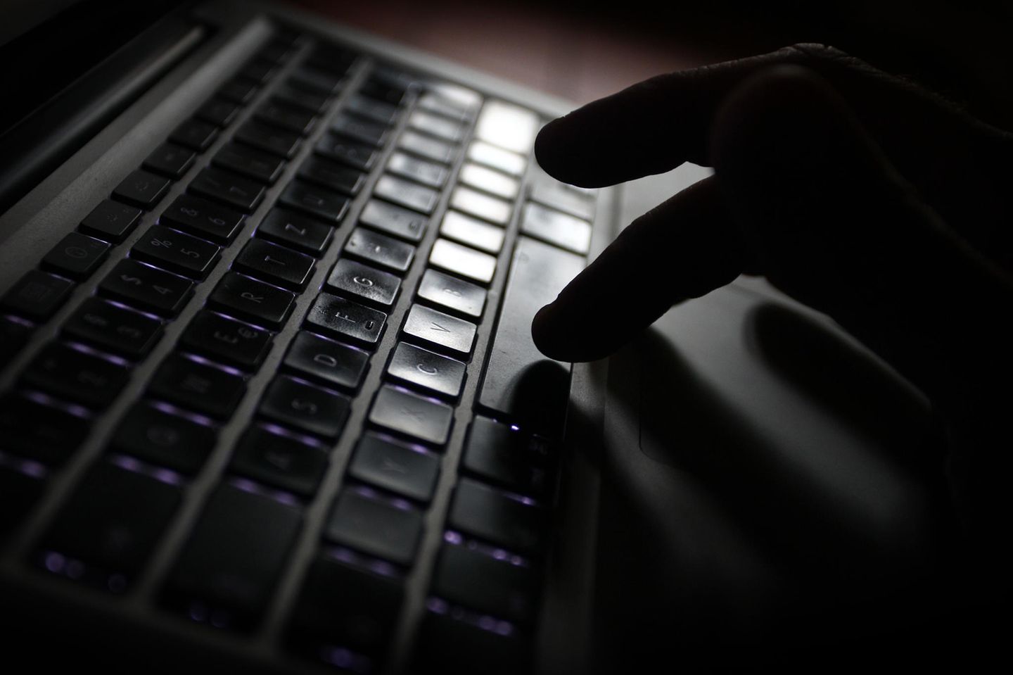 Mann tippt auf Laptoptastatur
