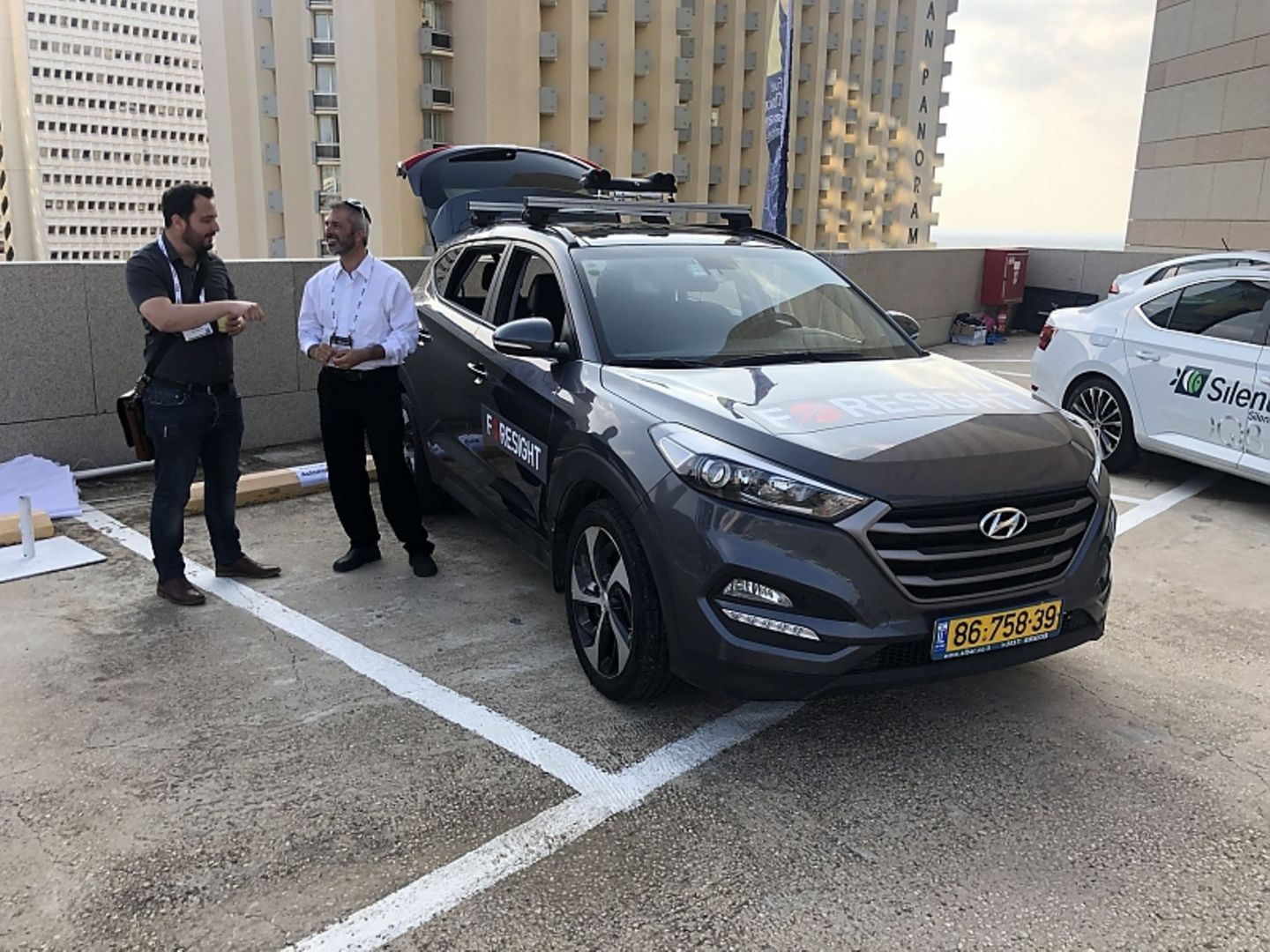 Benyamin Parto (rechts) mit seinem Hyundai SUV, auf dessen Dach vier Kameras montiert sind - zwei optische und zwei Wärmebildkam