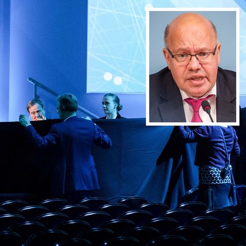 Helfer schirmen Bundeswirtschaftsminister Peter Altmaier nach seinem Sturz mit schwarzen Tüchern ab