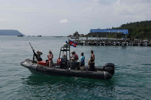 Taucher und Soldaten fahren mit einem Boot raus aufs Meer