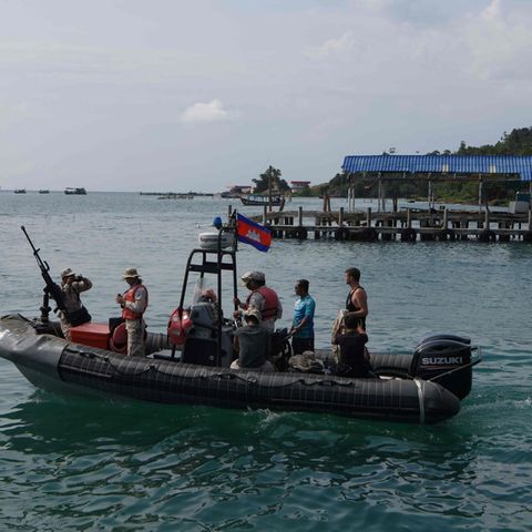 Taucher und Soldaten fahren mit einem Boot raus aufs Meer
