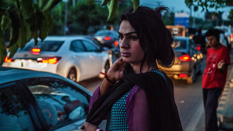 Eine junge Transgender-Frau bettelt an einer Straße