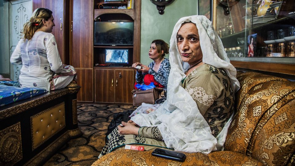 Drei Transgender-Frauen sitzen auf Bett und Sofa