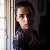 Eine junge Transgender-Frau steht an einem Fenster