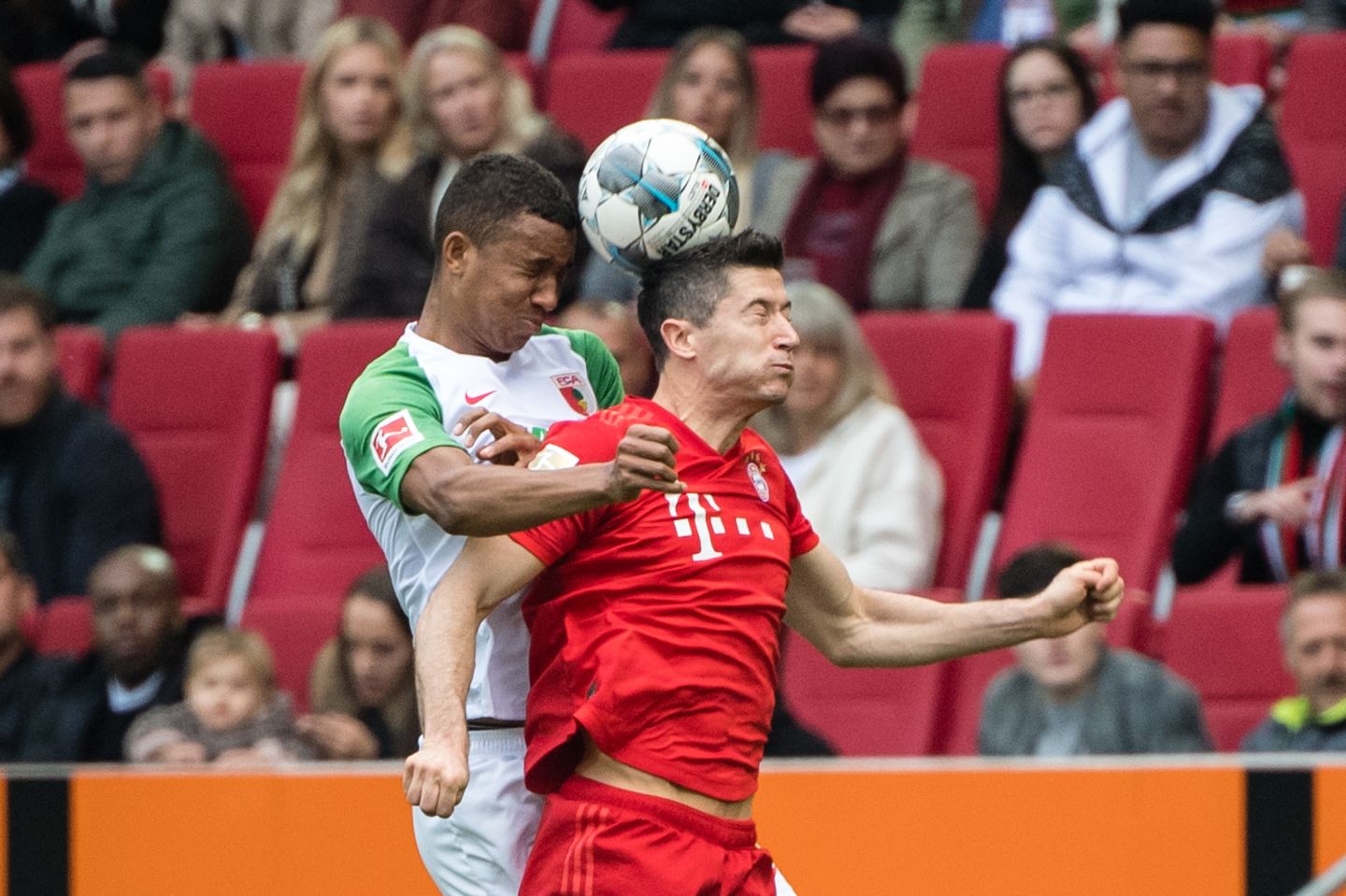 Bayern-Stürmer Robert Lewandowski und Augsburgs Felix Uduokai im Luftkampf