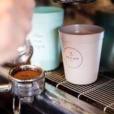 Ein Recup-Becher unter einer Kaffeemaschine