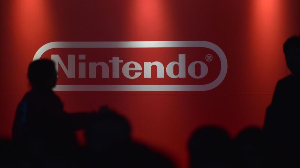 Menschen vor dem Nintendo-Logo. Die Nintendo Switch gehört zu den erfolgreichsten Konsolen des Unternehmens.