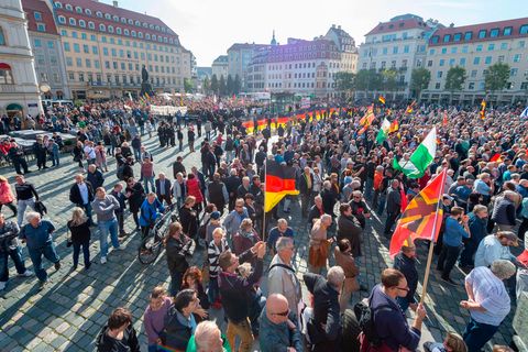 Teilnehmer einer Kundgebung von Pegida und Teilnehmer von Gegenkundgebungen stehen auf dem Altmarkt in Dresden