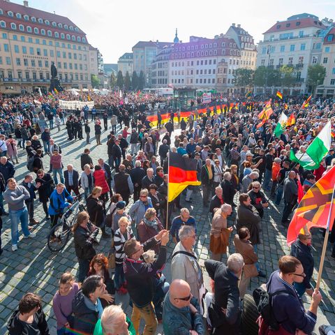 Teilnehmer einer Kundgebung von Pegida und Teilnehmer von Gegenkundgebungen stehen auf dem Altmarkt in Dresden