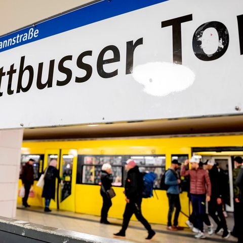 Eine U-Bahn der Linie 8 steht im Bahnhof Kottbusser Tor, während Fahrgäste ein- und aussteigen