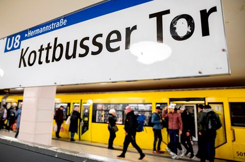Eine U-Bahn der Linie 8 steht im Bahnhof Kottbusser Tor, während Fahrgäste ein- und aussteigen