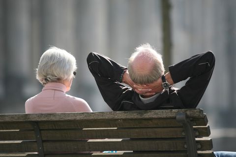 Ein Rentnerpaar sitzt auf einer Bank