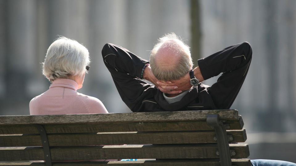 Ein Rentnerpaar sitzt auf einer Bank