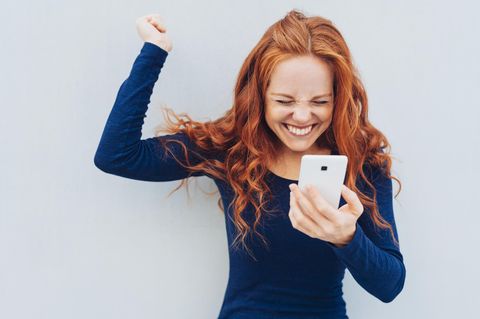 Frau freut sich über Smartphone