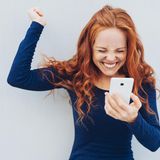 Frau freut sich über Smartphone