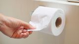 Erkältung: Ein Mann greift zu einer Rolle Klopapier