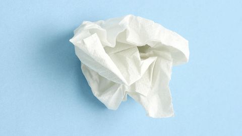 Erkältung: Ein zerknülltes Taschentuch liegt auf blauem Untergrund