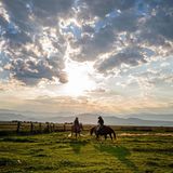 Vicky und Caitlyn auf ihren Pferden vor einer malerischen Kulisse