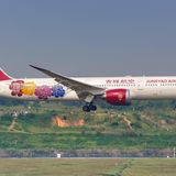 Diese Boeing 787 hat Juneyao Airlines, eine chinesische Fluggesellschaft mit Sitz in Shanghai, mit vier Blüten im Heckbereich verziert.